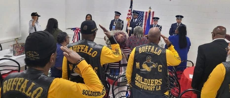 Buffalo Soldiers Shreveport members saluting at Memorial Day indoor ceremony